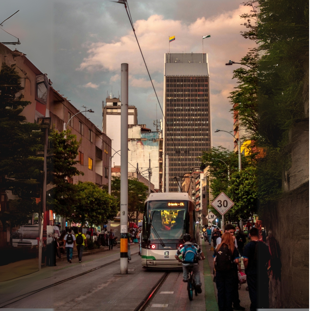 Fotografía del tranvía y de fondo el edificio coltejer de Medellín